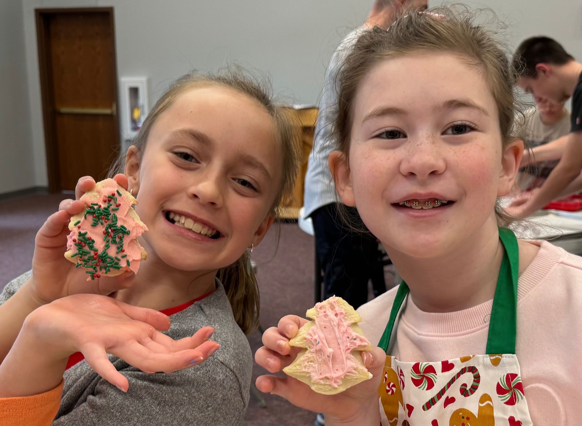 Two children smile holding cookies