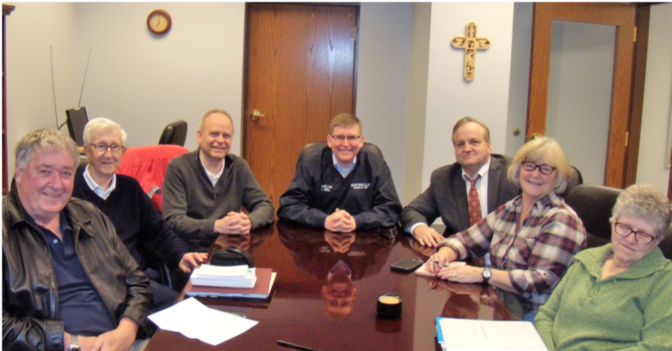The church council smiles in a boardroom