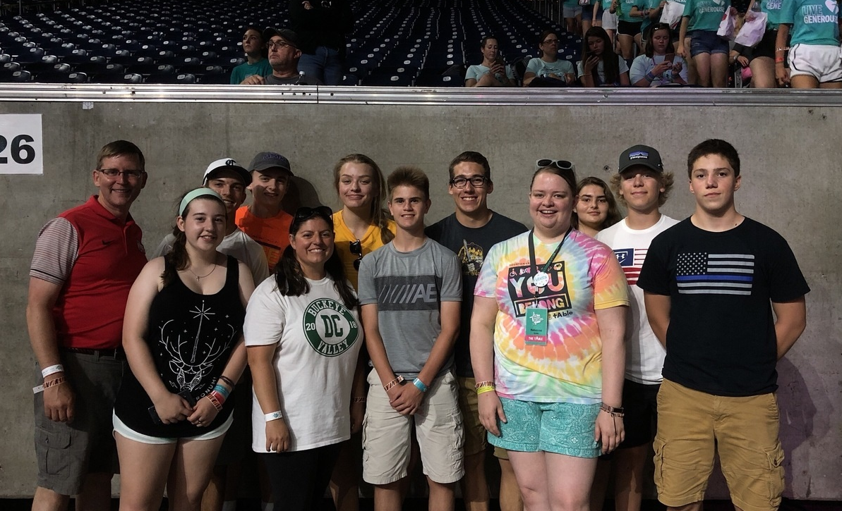 A group of young adults smile in a stadium