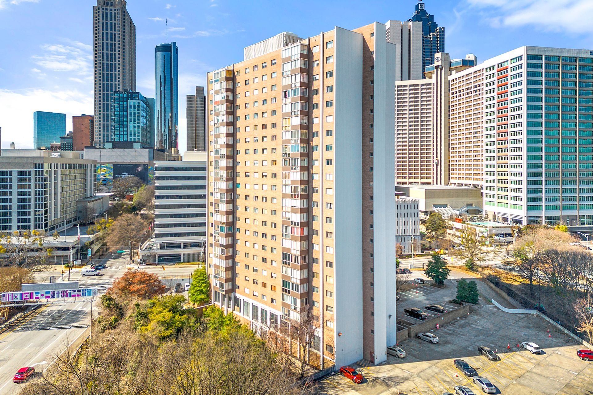 An aerial view of a tall building with a city skyline in the background.