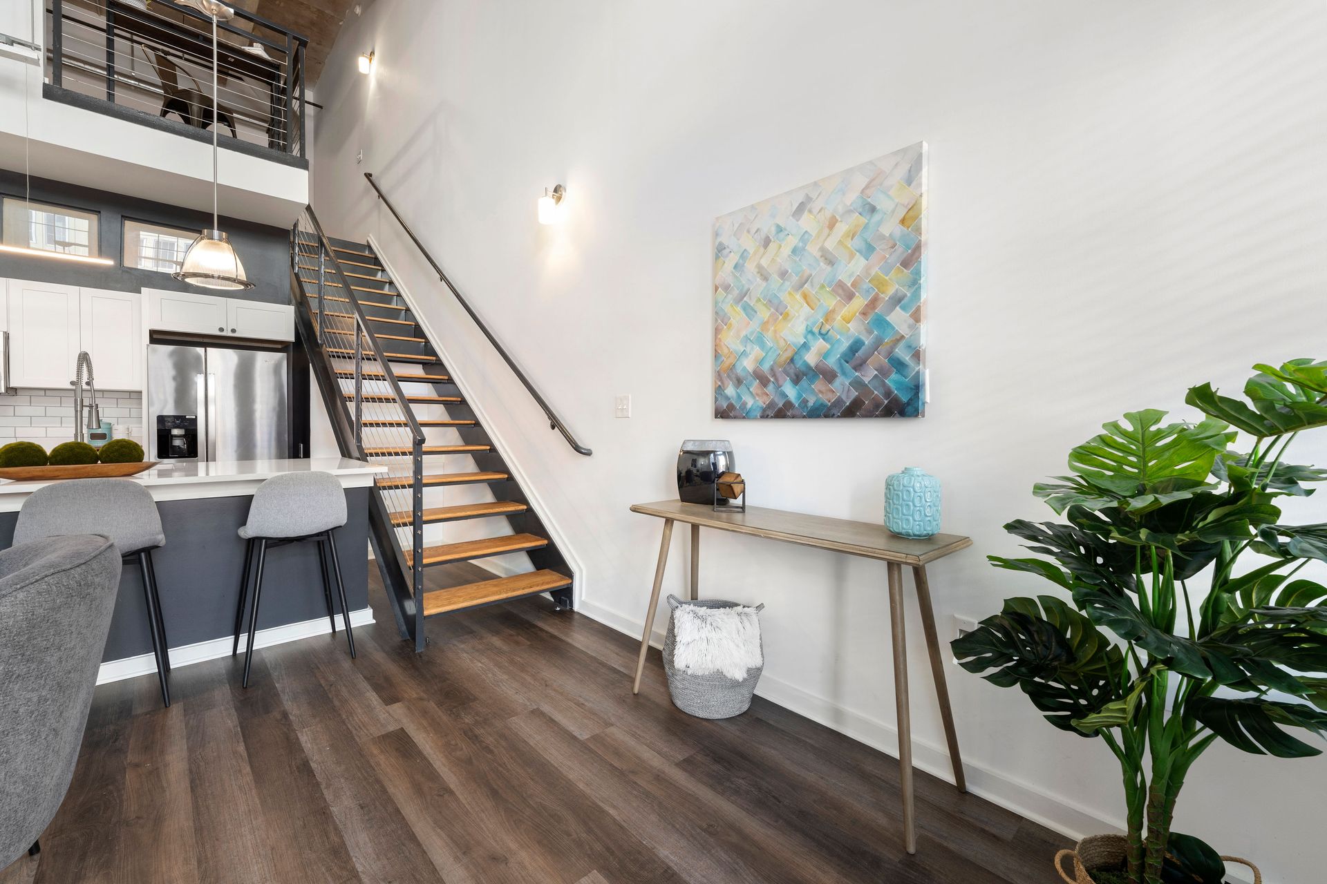 A living room with hardwood floors and stairs leading up to the second floor.