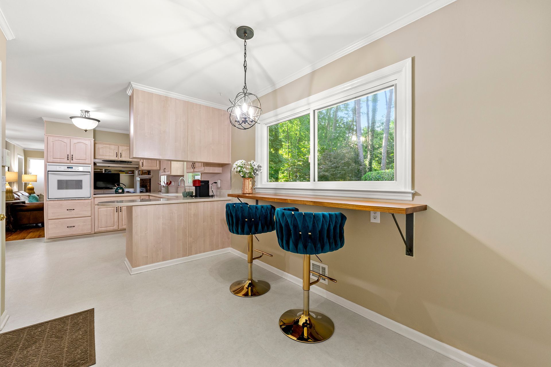 A kitchen with two bar stools and a window.