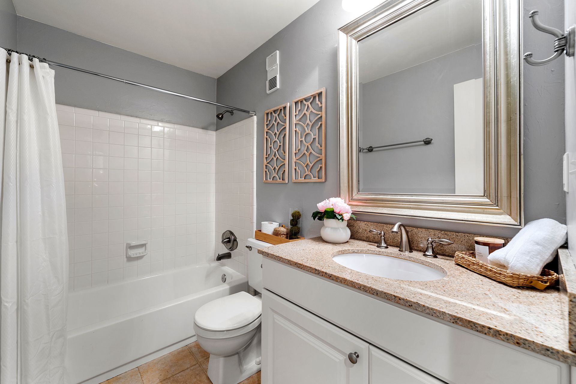 A bathroom with a sink , toilet , bathtub and mirror.