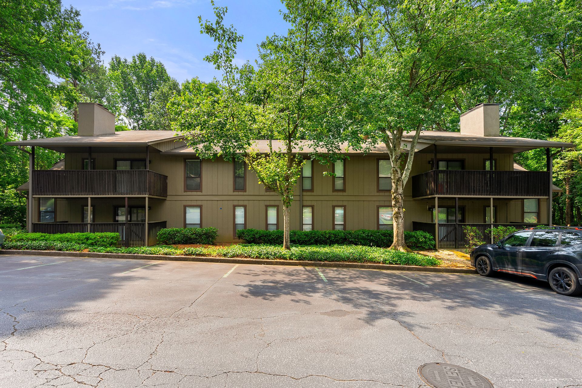 A large apartment building with a car parked in front of it.