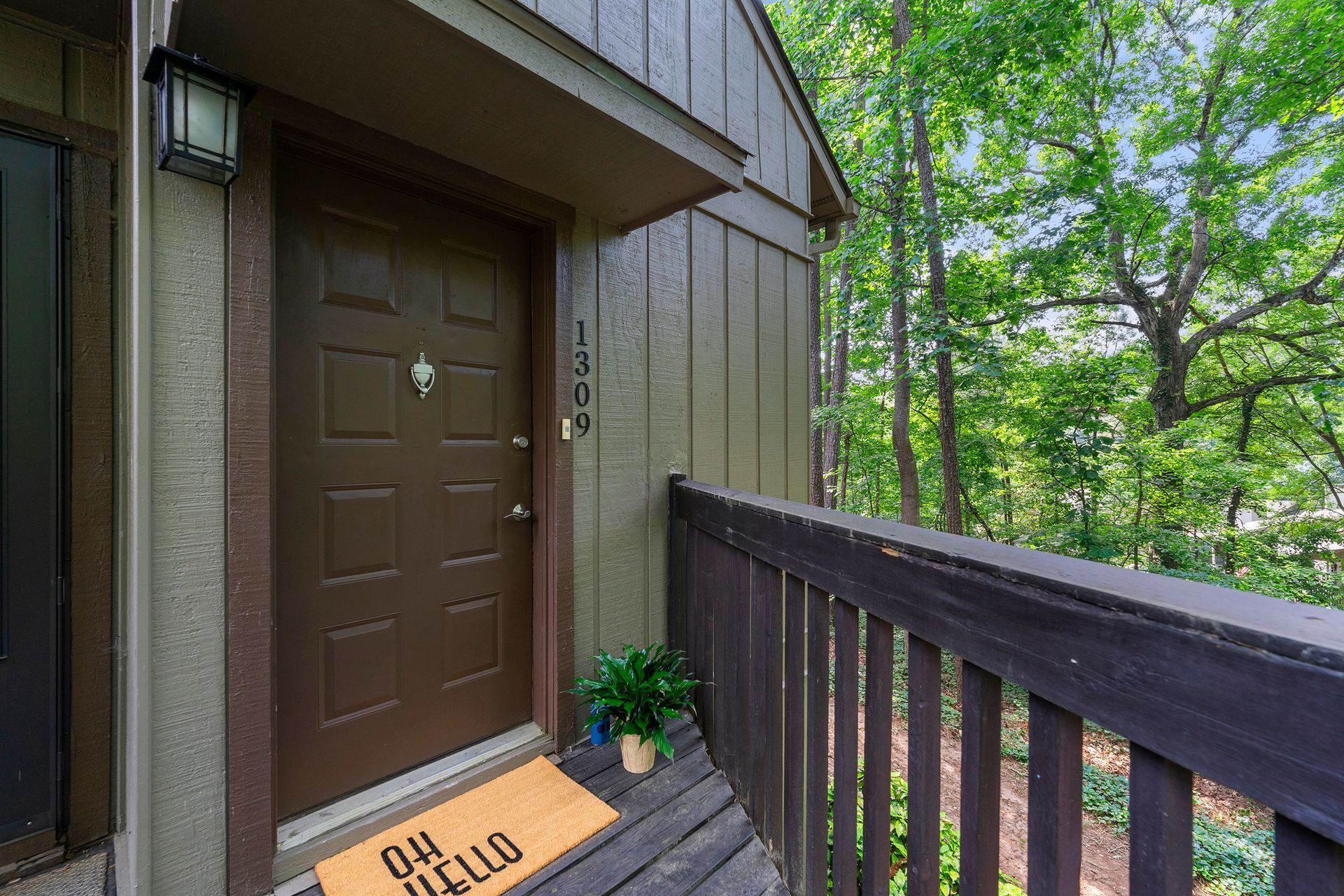 The front door of a house with a welcome mat on the porch.