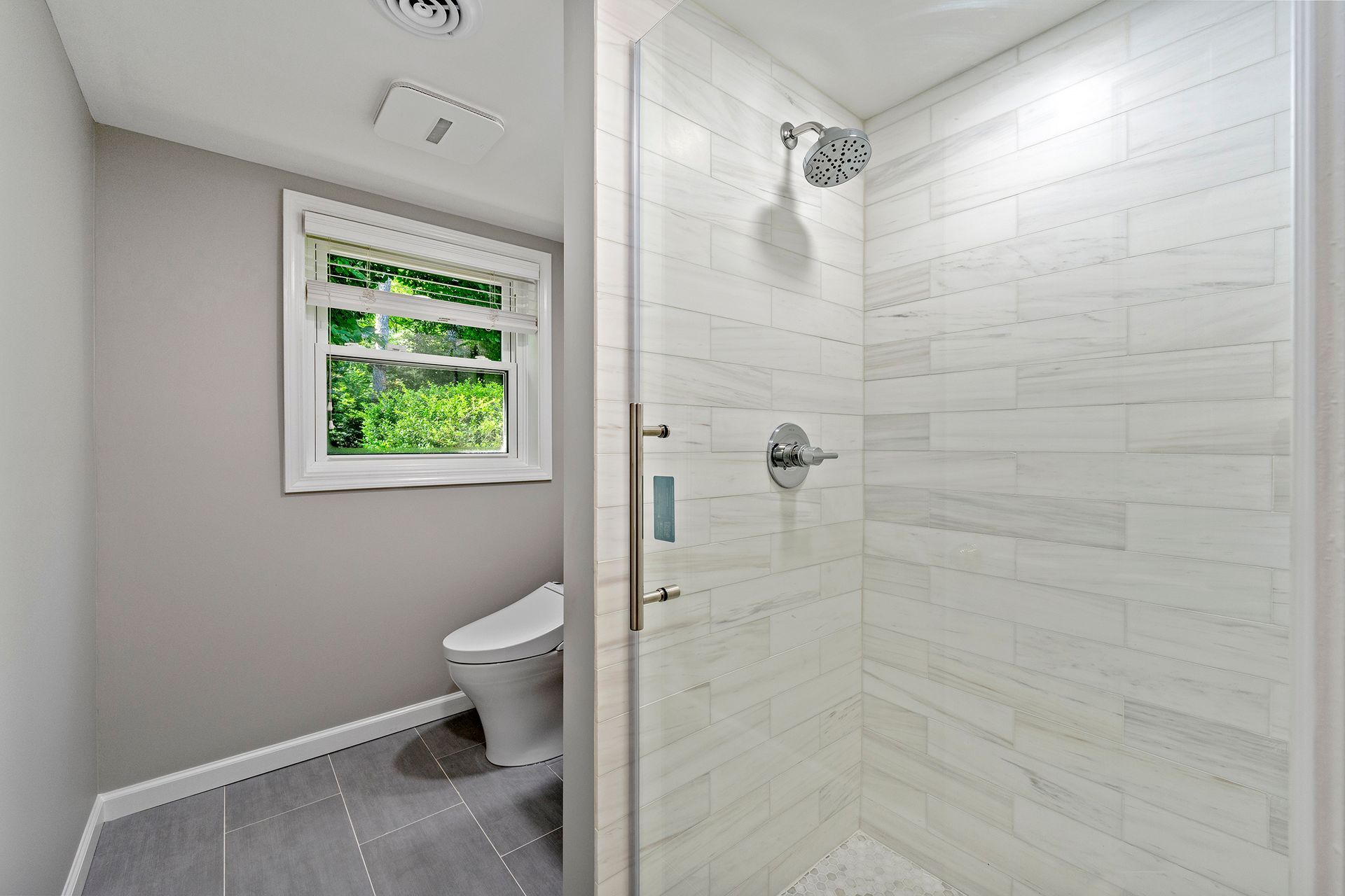 A bathroom with a toilet and a walk in shower.