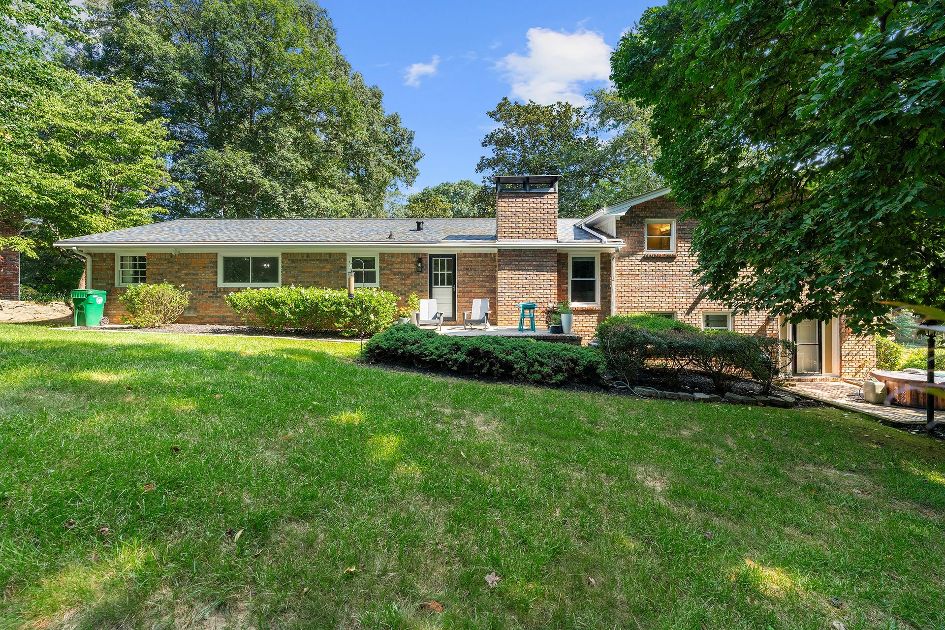 A large brick house with a large lawn in front of it.