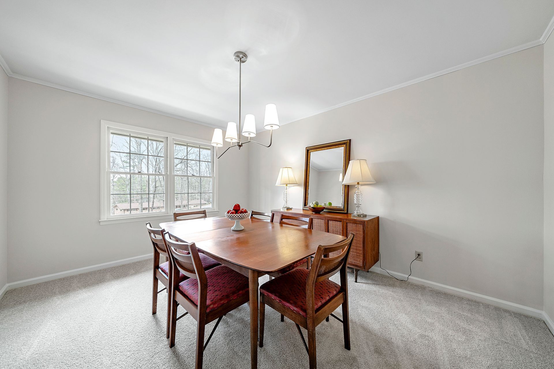 A dining room with a table and chairs and a chandelier.