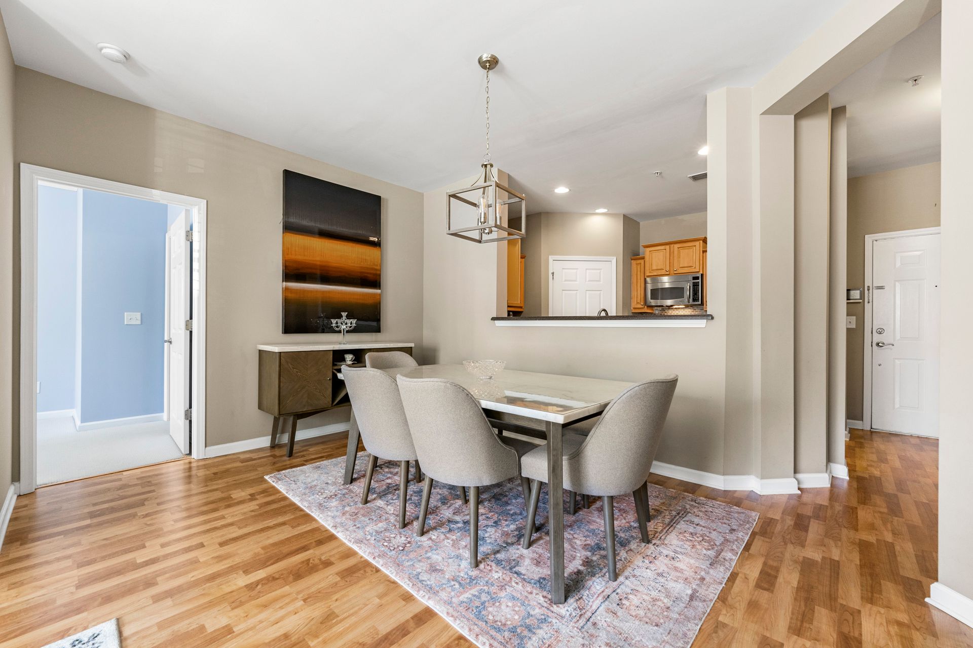 A dining room with a table and chairs and a rug.