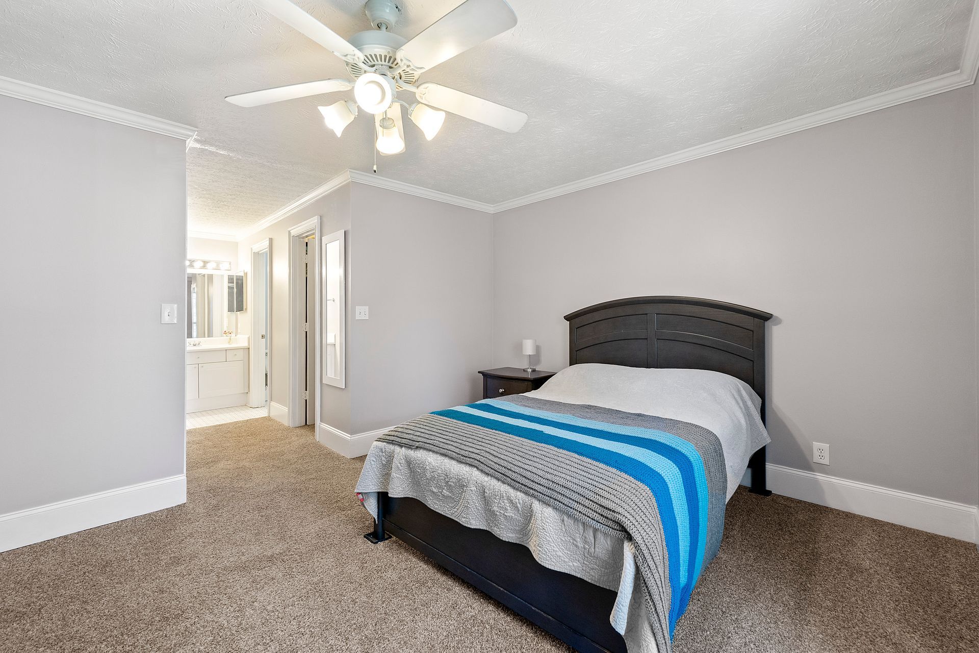 A bedroom with a bed and a ceiling fan.