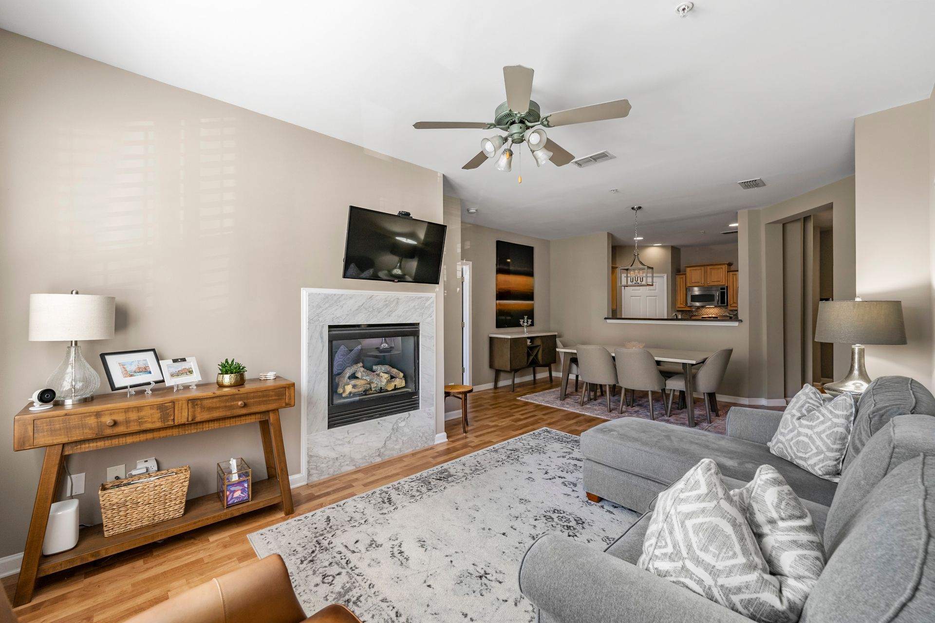 A living room with a fireplace and a ceiling fan.
