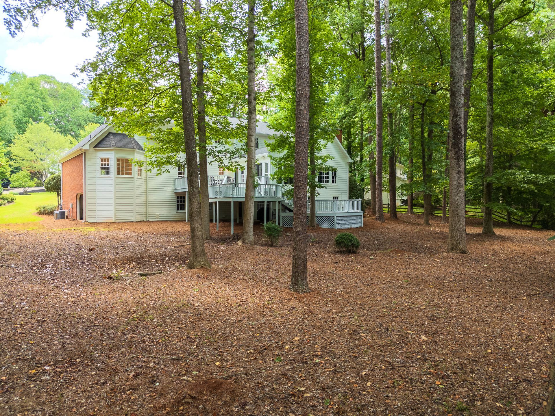 A house is surrounded by trees in the middle of a forest.