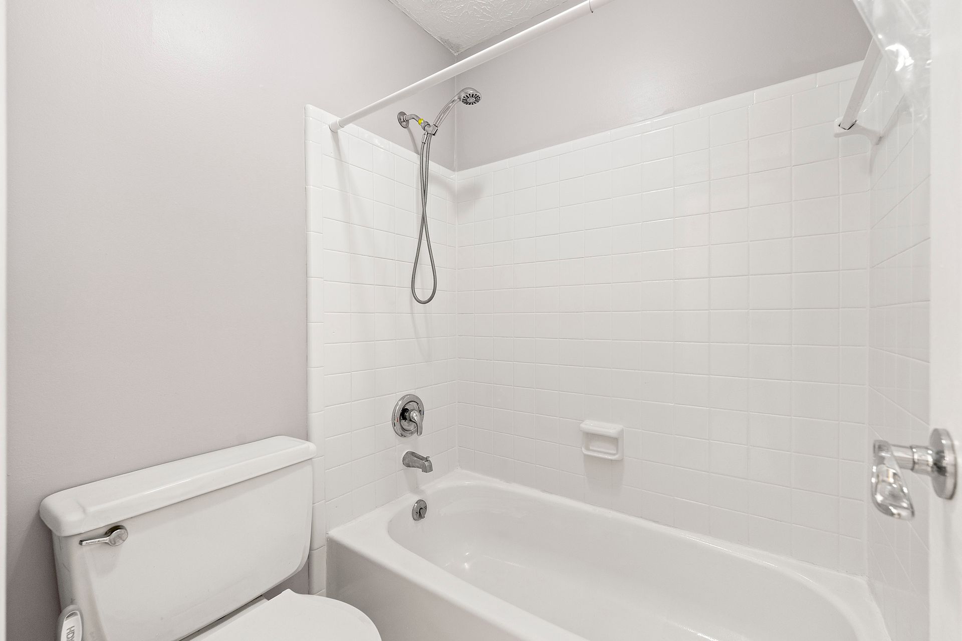 A bathroom with a toilet , bathtub and shower.