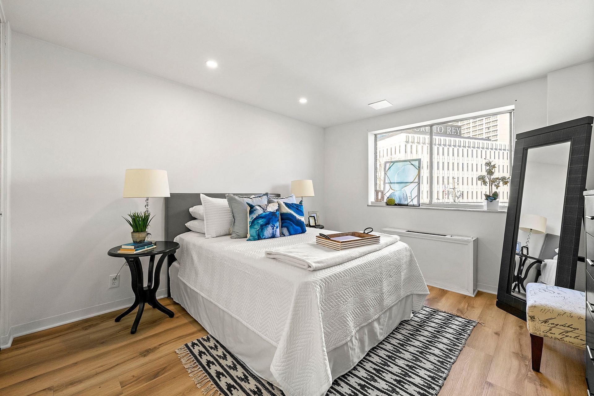 A bedroom with a bed , mirror , table and chairs.