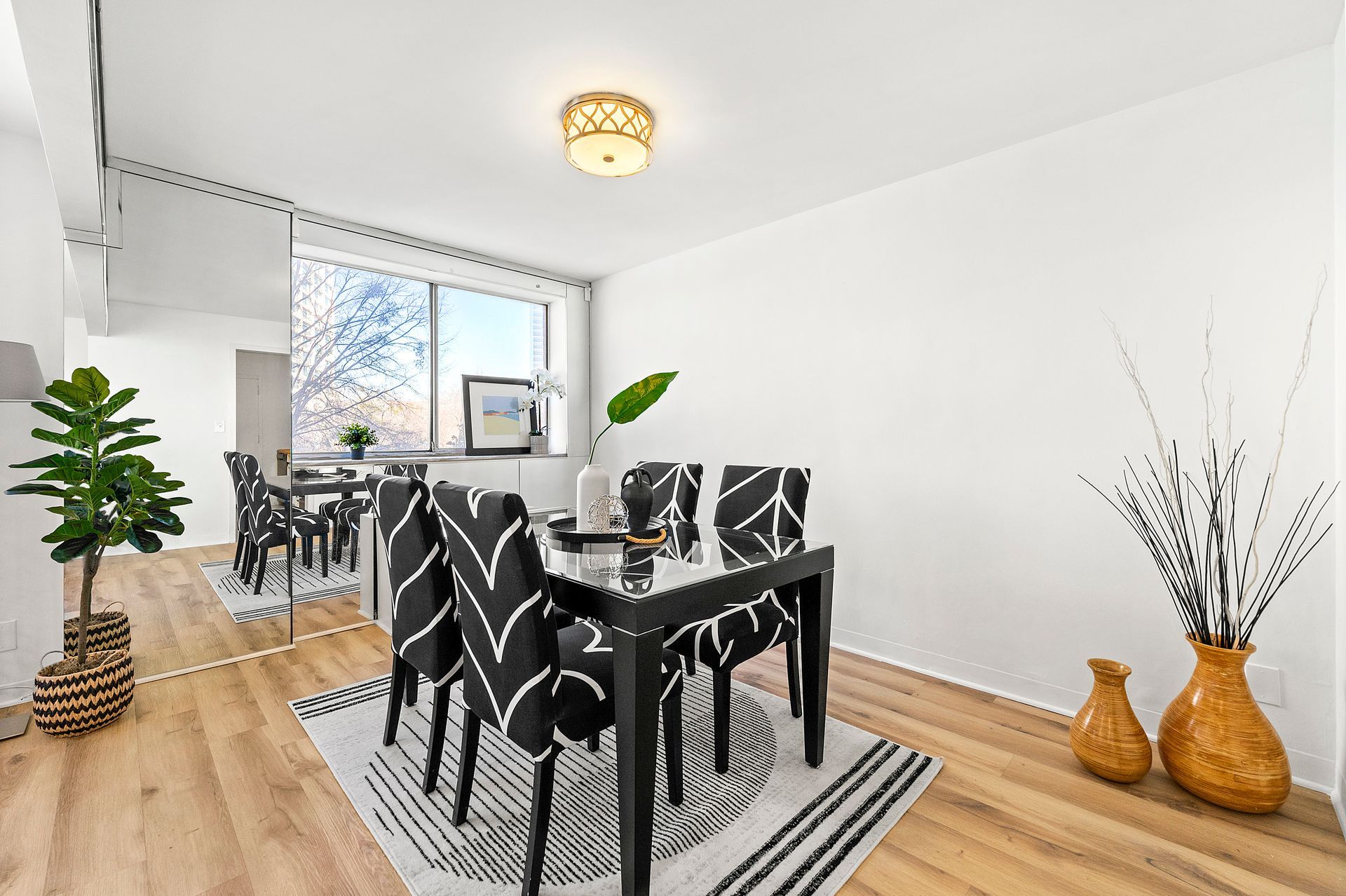 A dining room with a table and chairs and a rug.