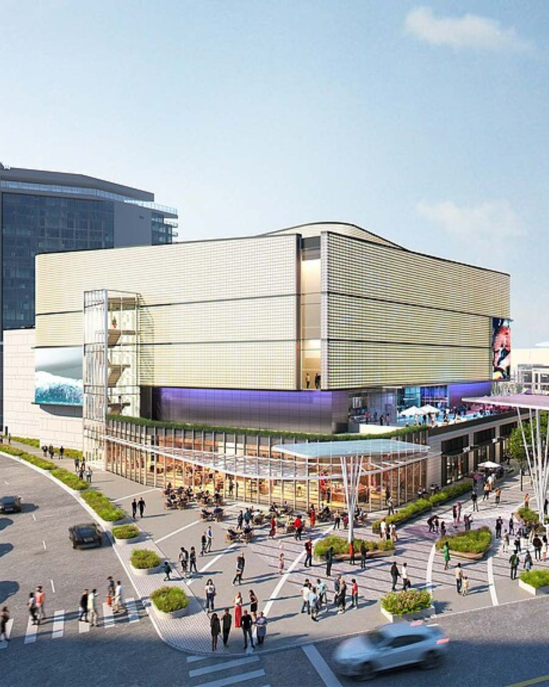 Modern shopping center building with a glass-enclosed ground level, outdoor dining area, and pedestrians on a plaza.