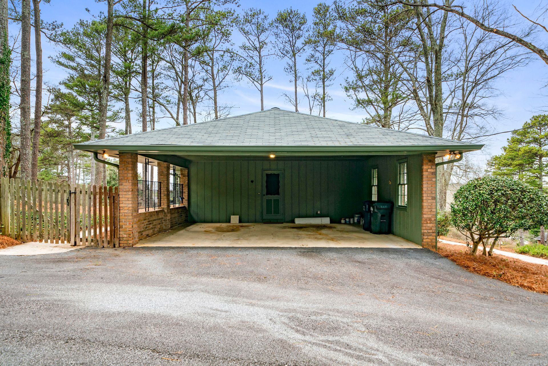 A house with a garage and a driveway surrounded by trees