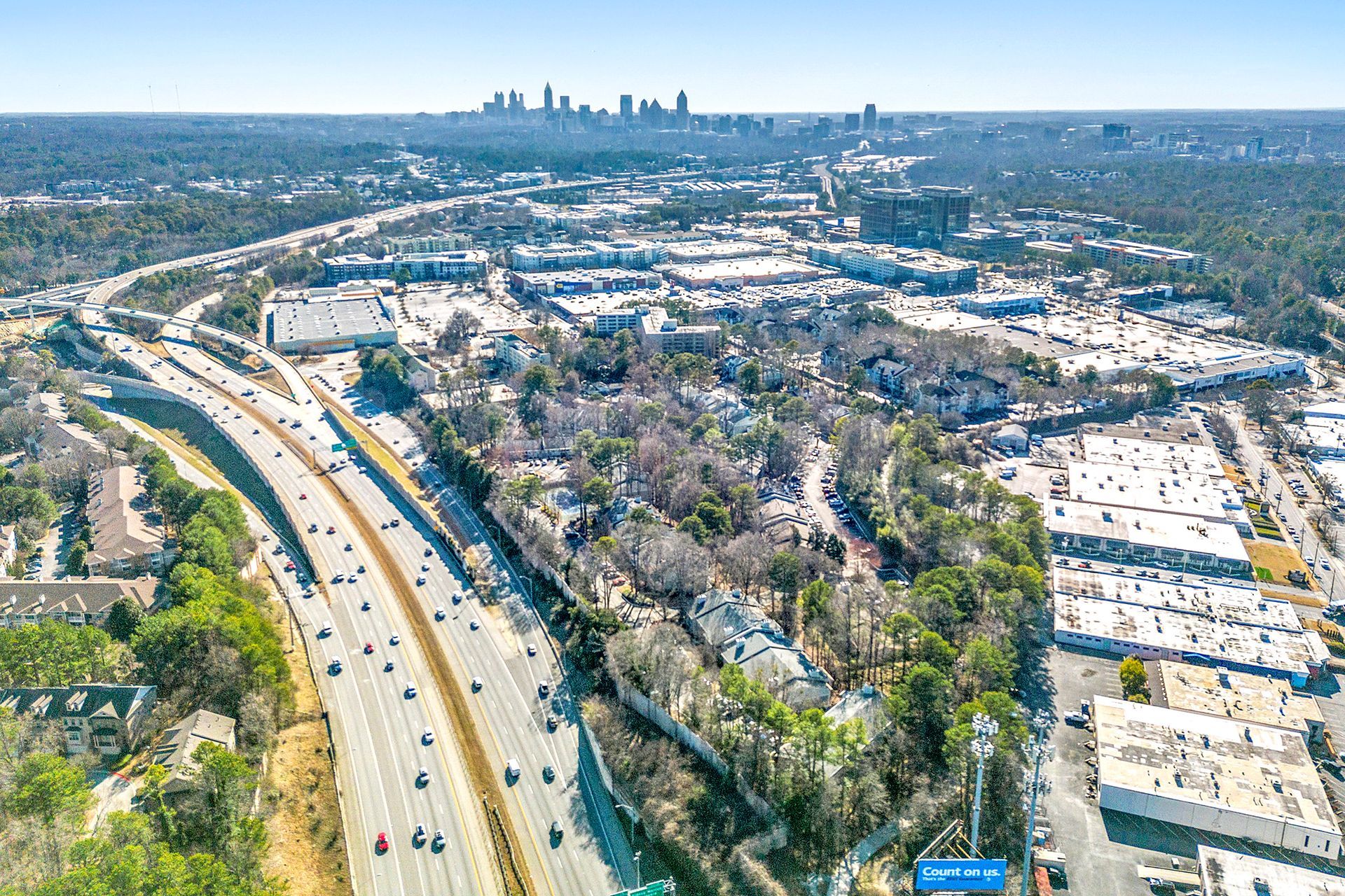 An aerial view of a highway with a city in the background.