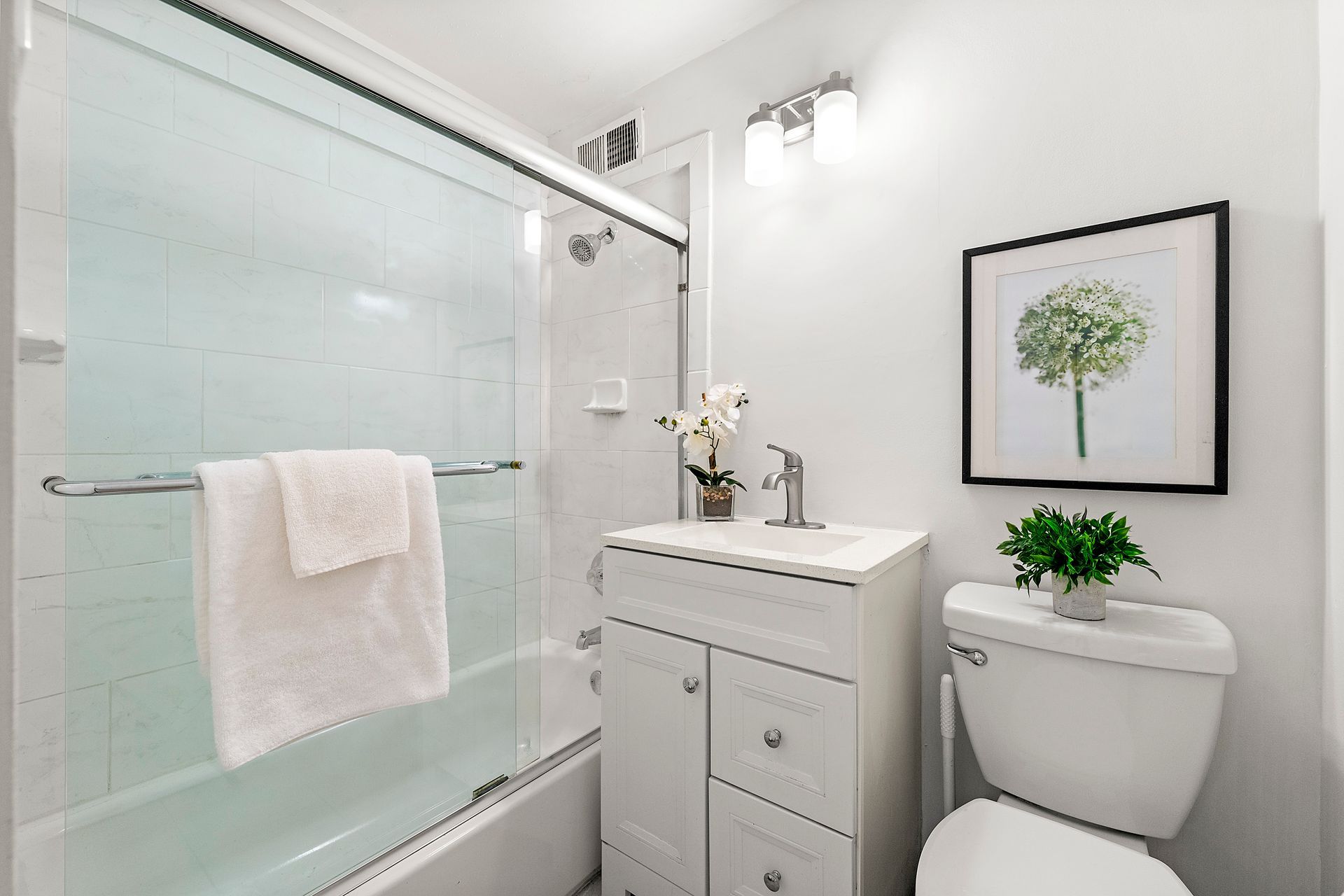 A bathroom with a toilet , sink , and shower.