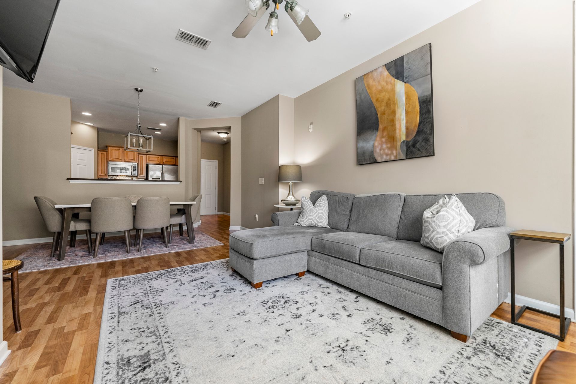 A living room with a gray sectional couch and a rug.