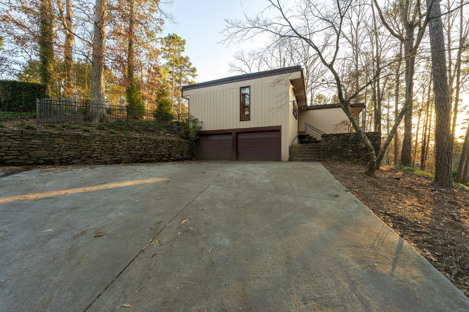 A house with a garage and stairs in the woods