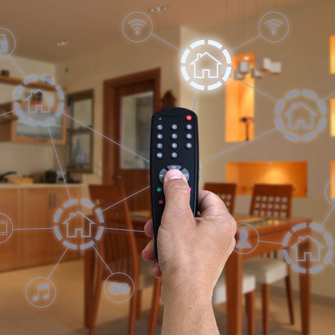 Hand holding remote in smart home dining room, controlling linked devices.