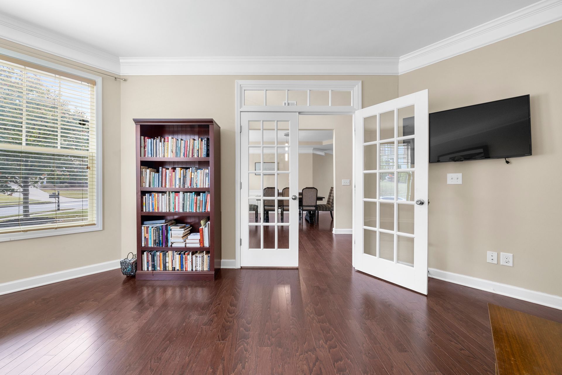 A living room with a bookshelf and a flat screen tv.