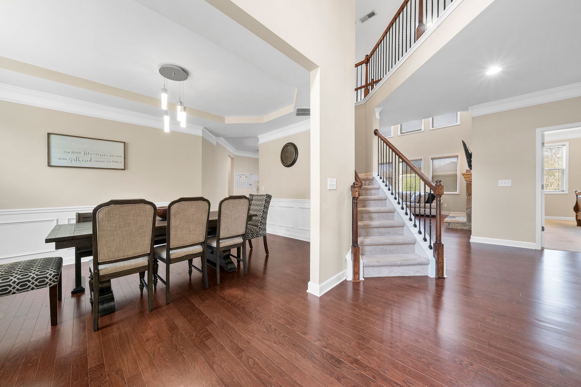 A dining room with a table and chairs and stairs in a house.