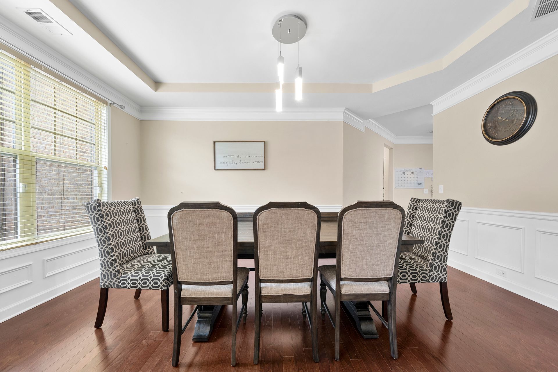 A dining room with a table and chairs and a window.
