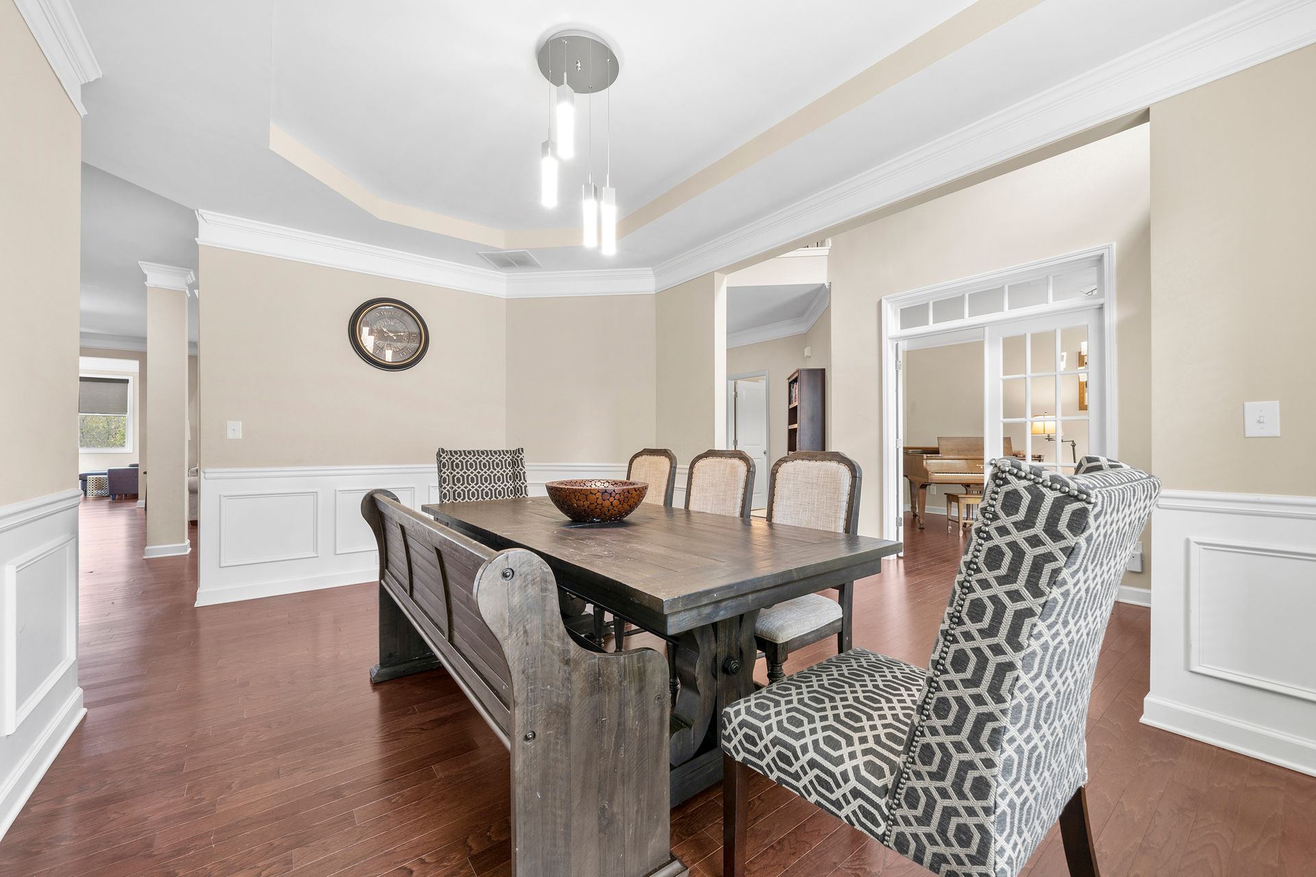 A dining room with a table and chairs and a bench.