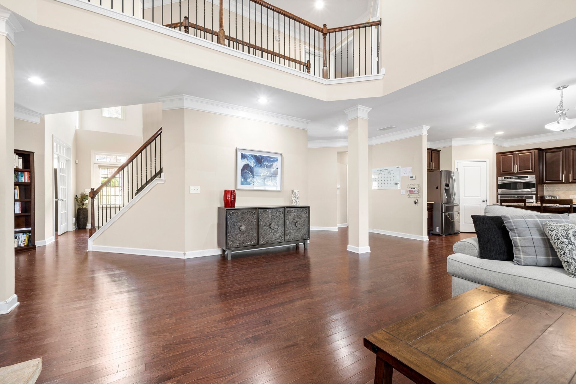 A living room in a house with hardwood floors and a staircase.