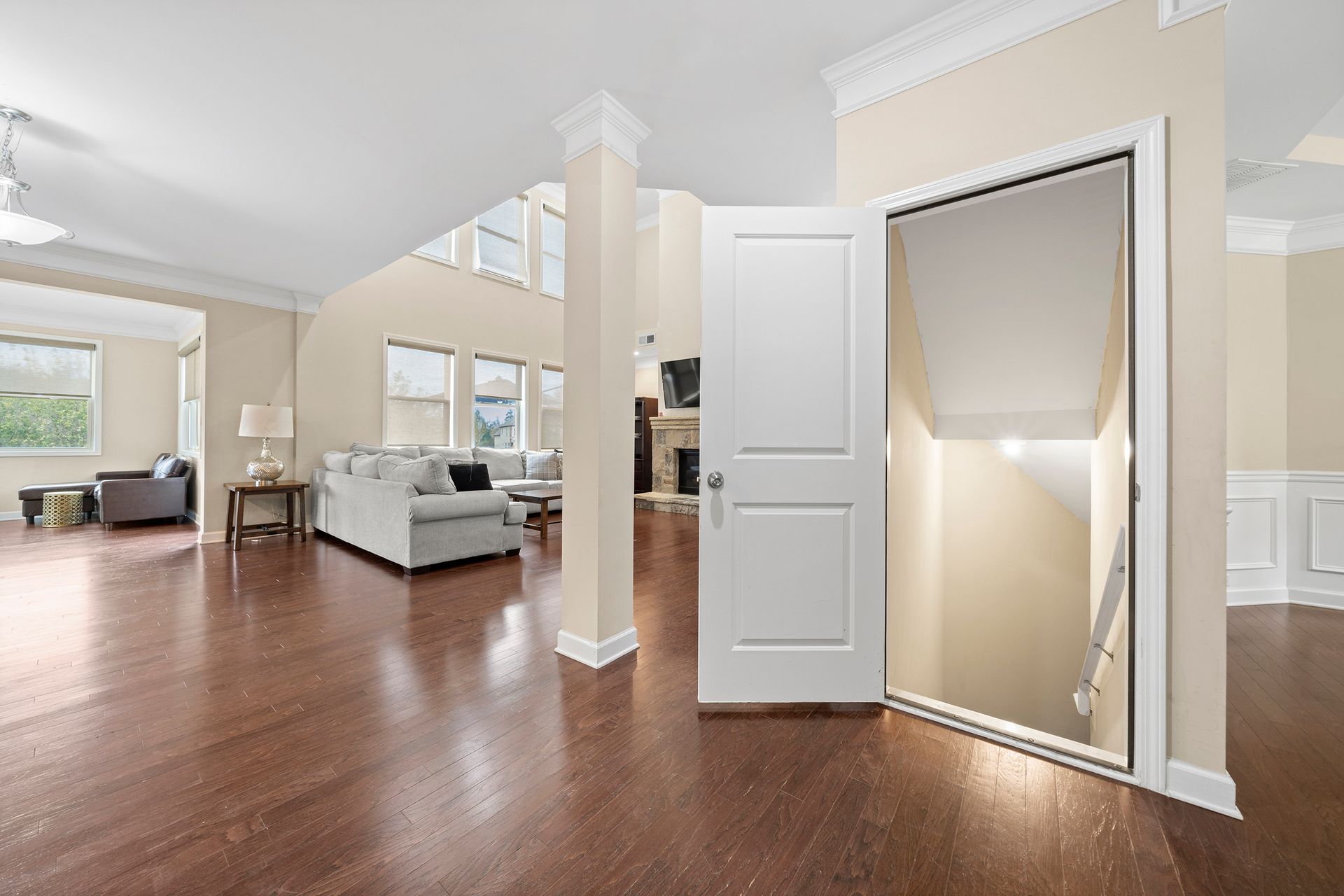 A living room with hardwood floors and a staircase leading to the second floor.