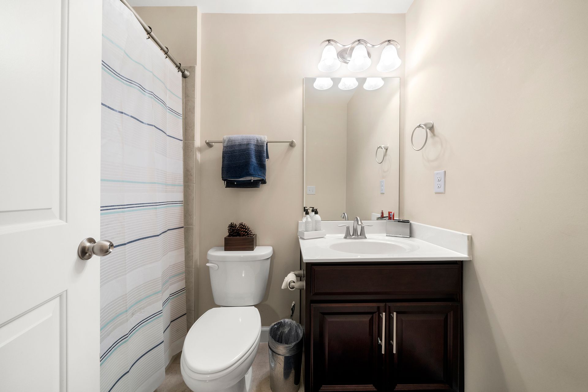 A bathroom with a toilet , sink , and shower curtain.