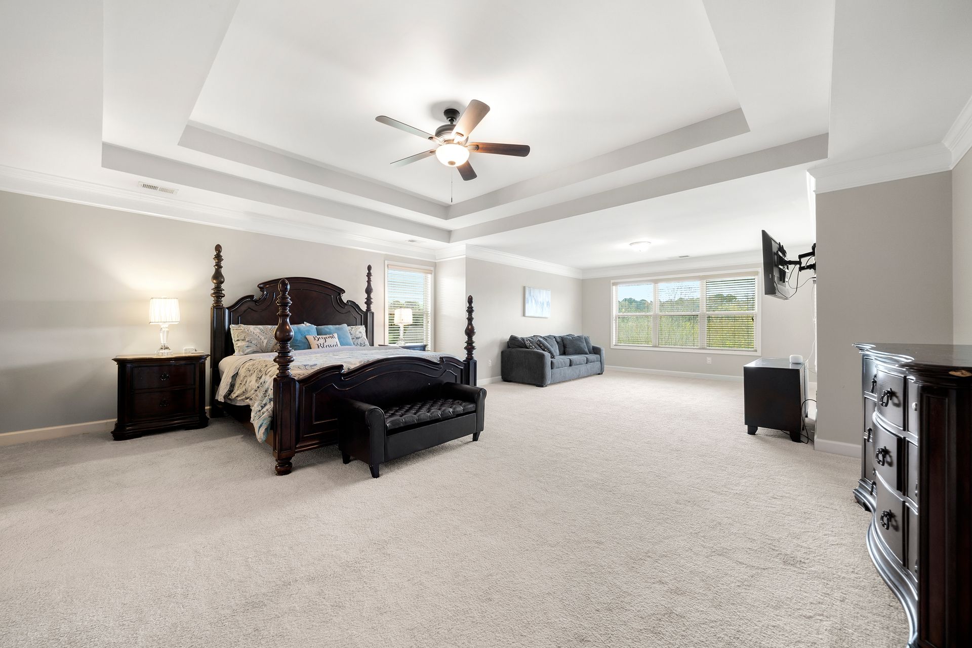A large bedroom with a king size bed and a ceiling fan.