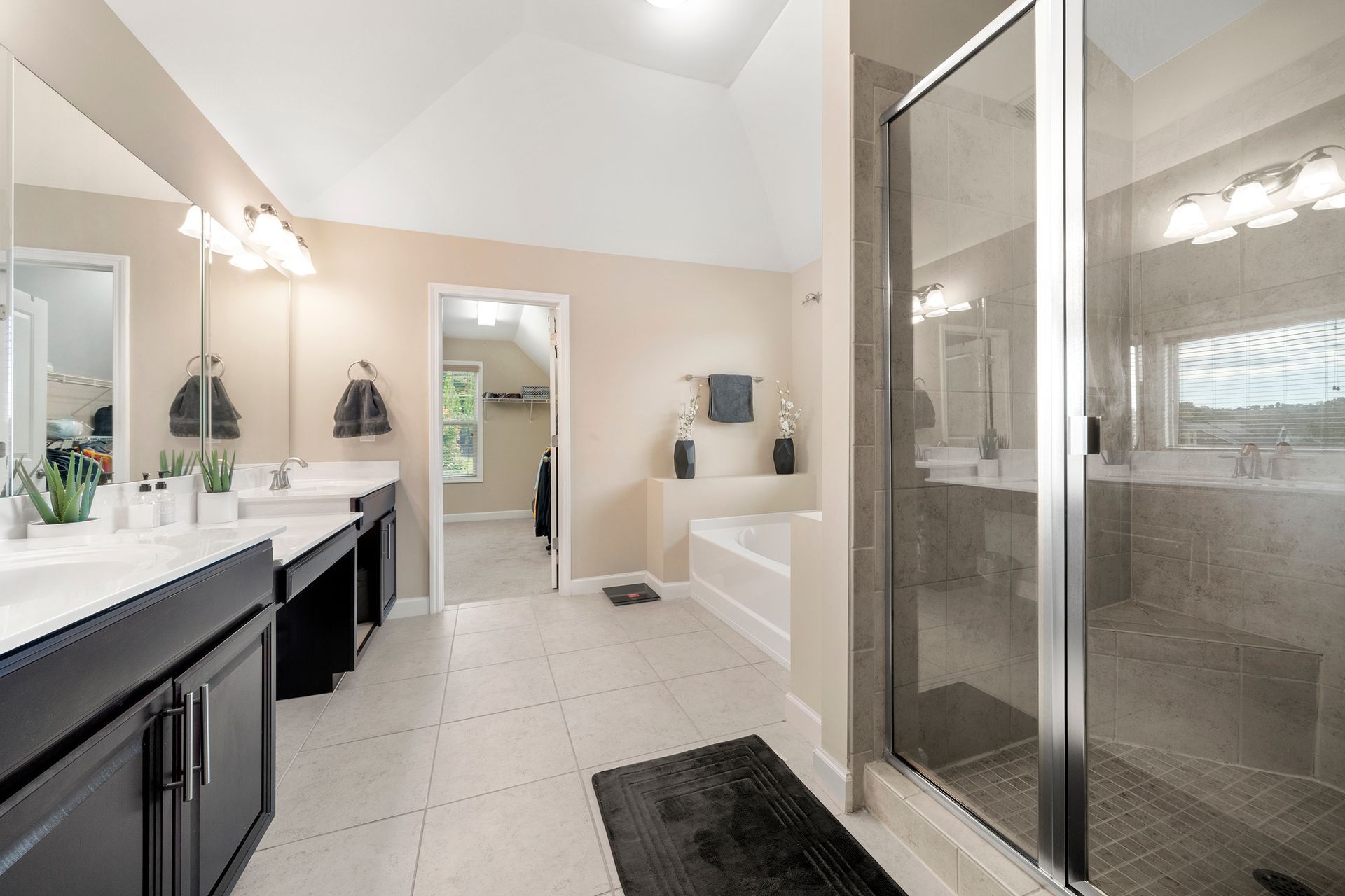 A bathroom with two sinks and a walk in shower.