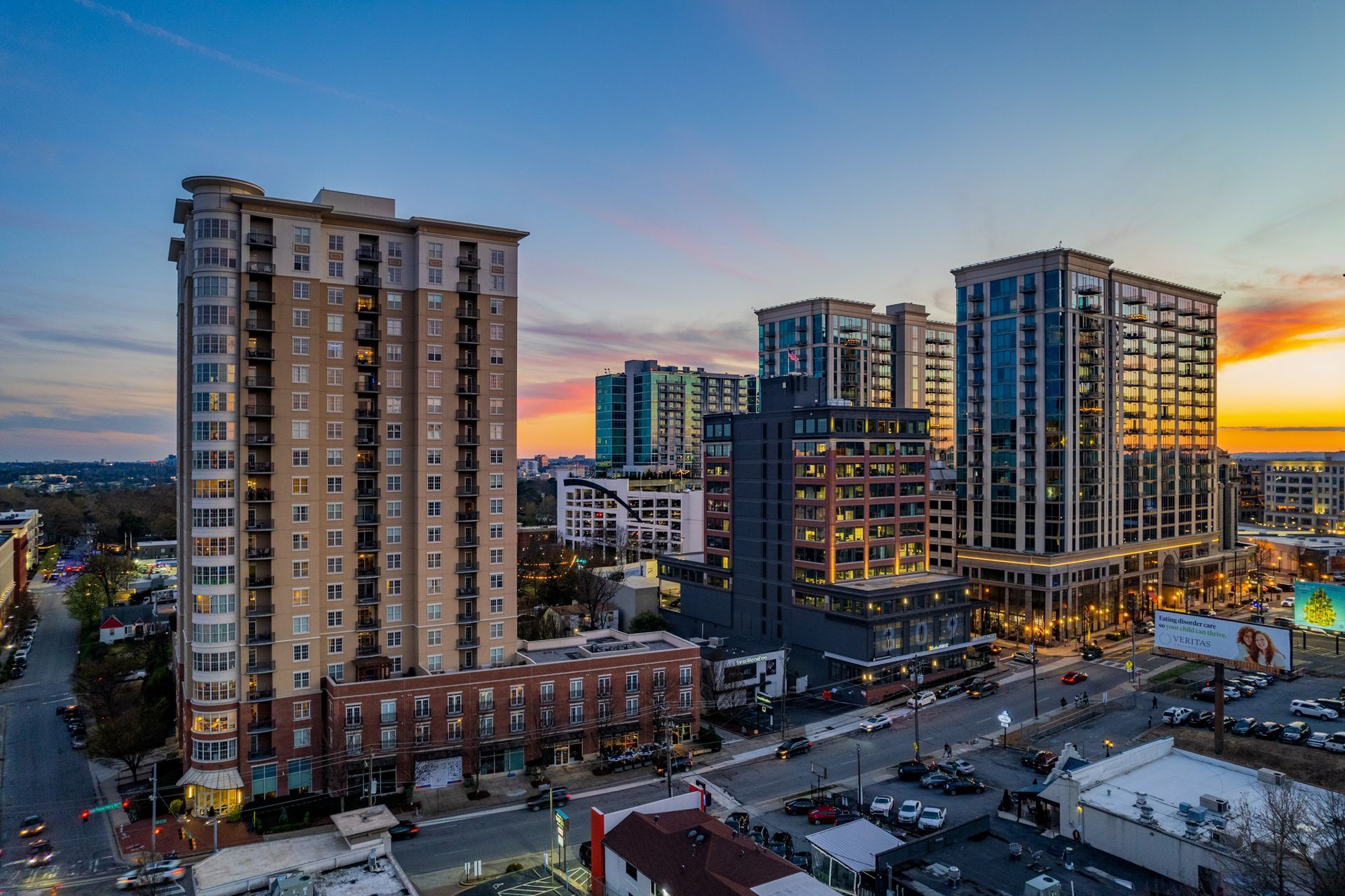 An aerial view of a city at sunset with a lot of tall buildings.