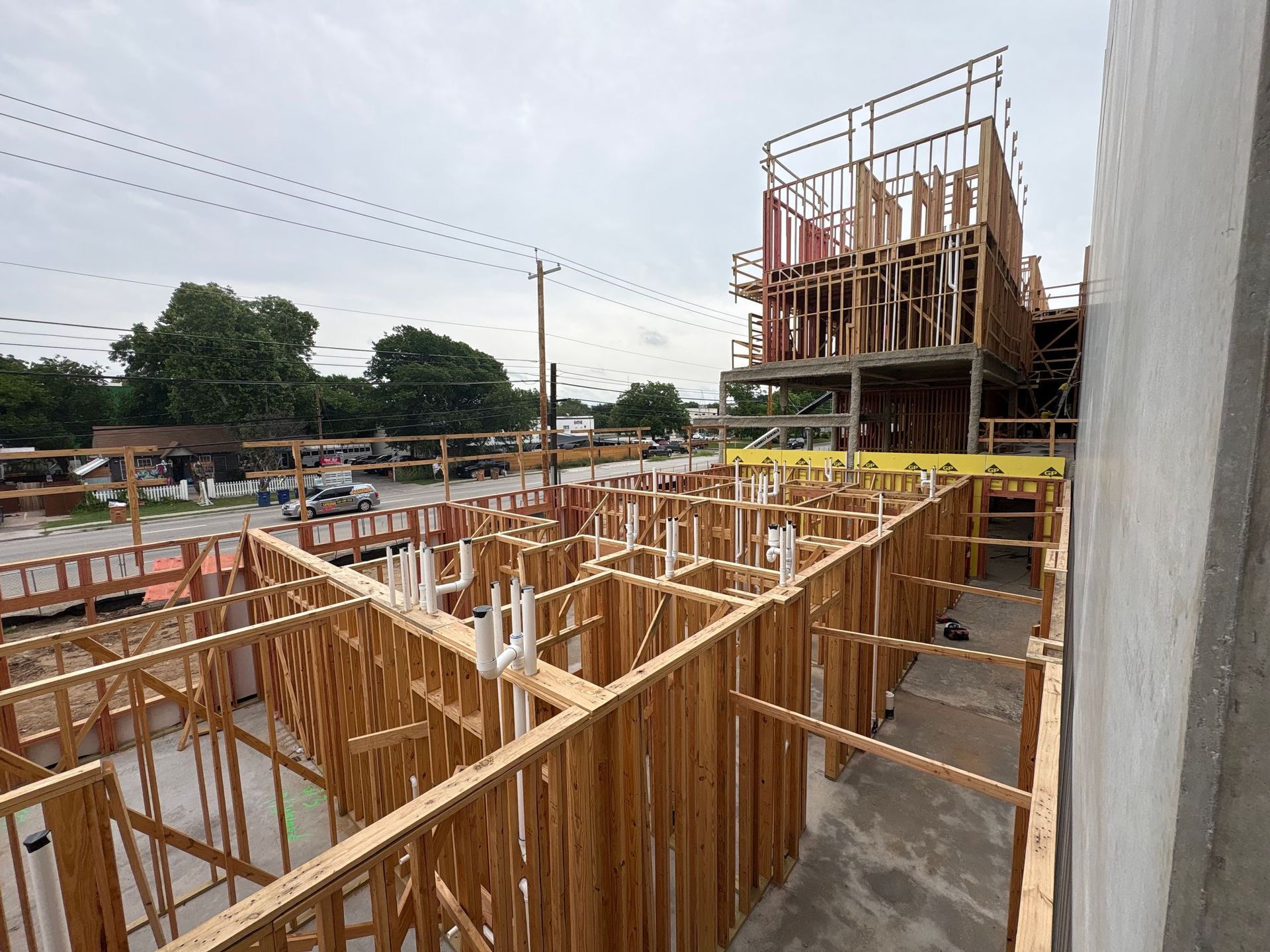 Construction site with wooden framing for a building under construction and scaffolding against a cloudy sky
