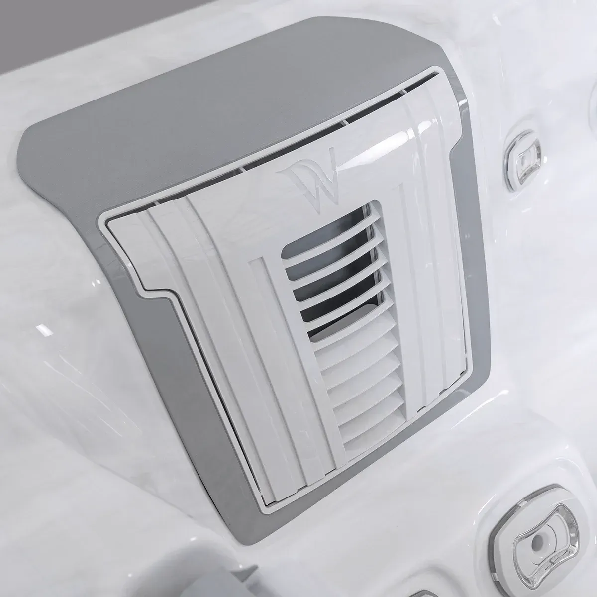 Close-up of a gray and white spa vent on the side of a white hot tub.