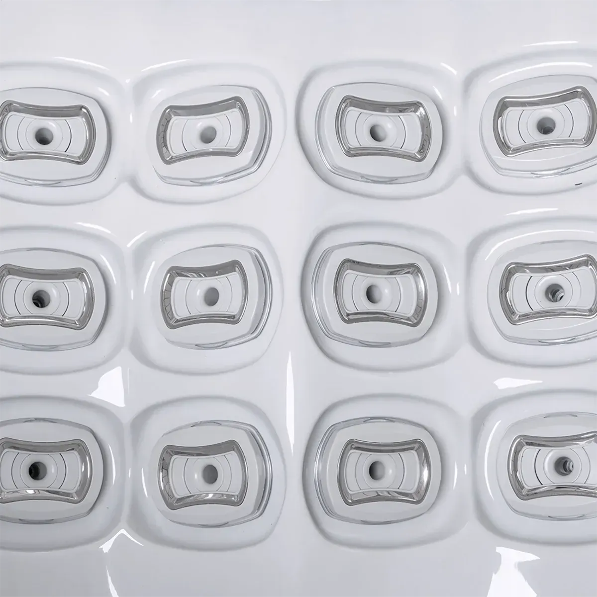 Close-up of a white textured surface with twelve recessed, rounded rectangular shapes with concentric silver borders.
