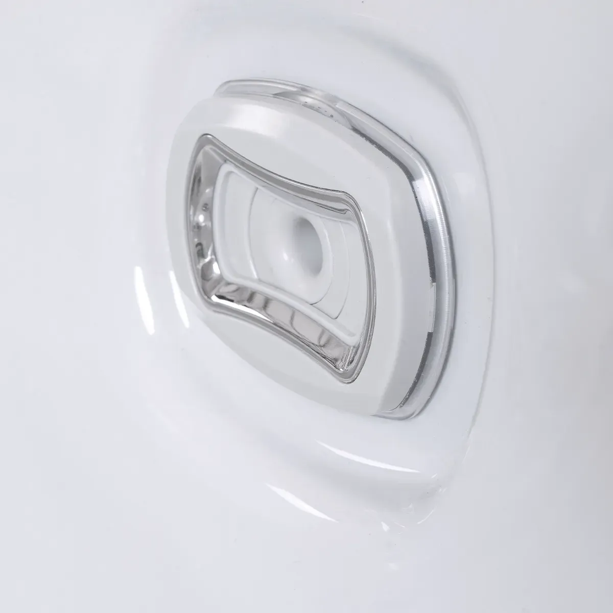 White hot tub jet with a chrome-colored trim and a small center hole.
