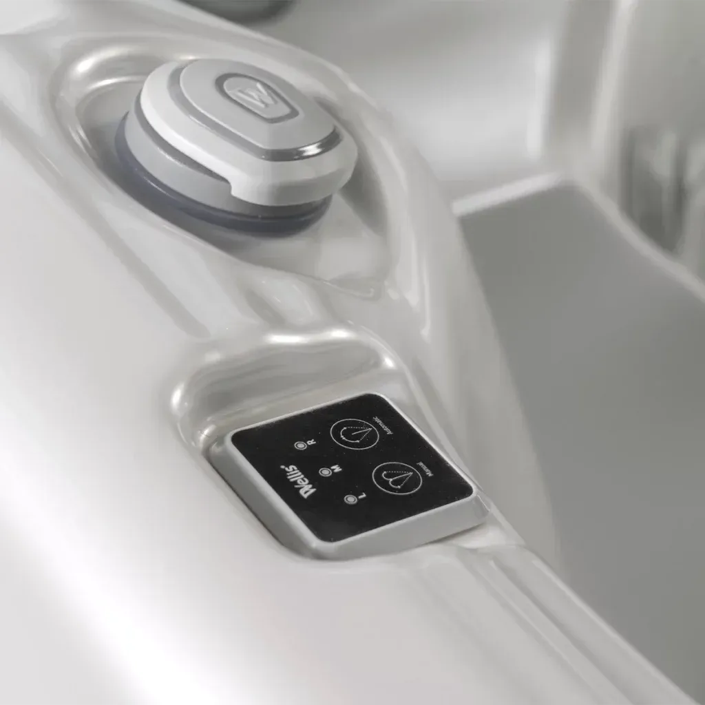 Close-up of a spa control panel with buttons and a lid. White spa interior.