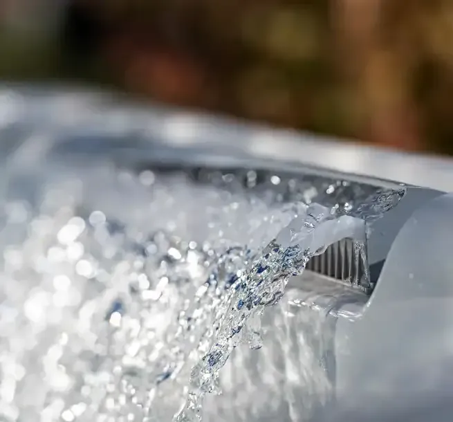Close-up of water cascading from a spa's edge, creating a blurred, sparkling effect.