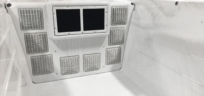 White interior with a central panel featuring vents and two dark openings, possibly a cooler.