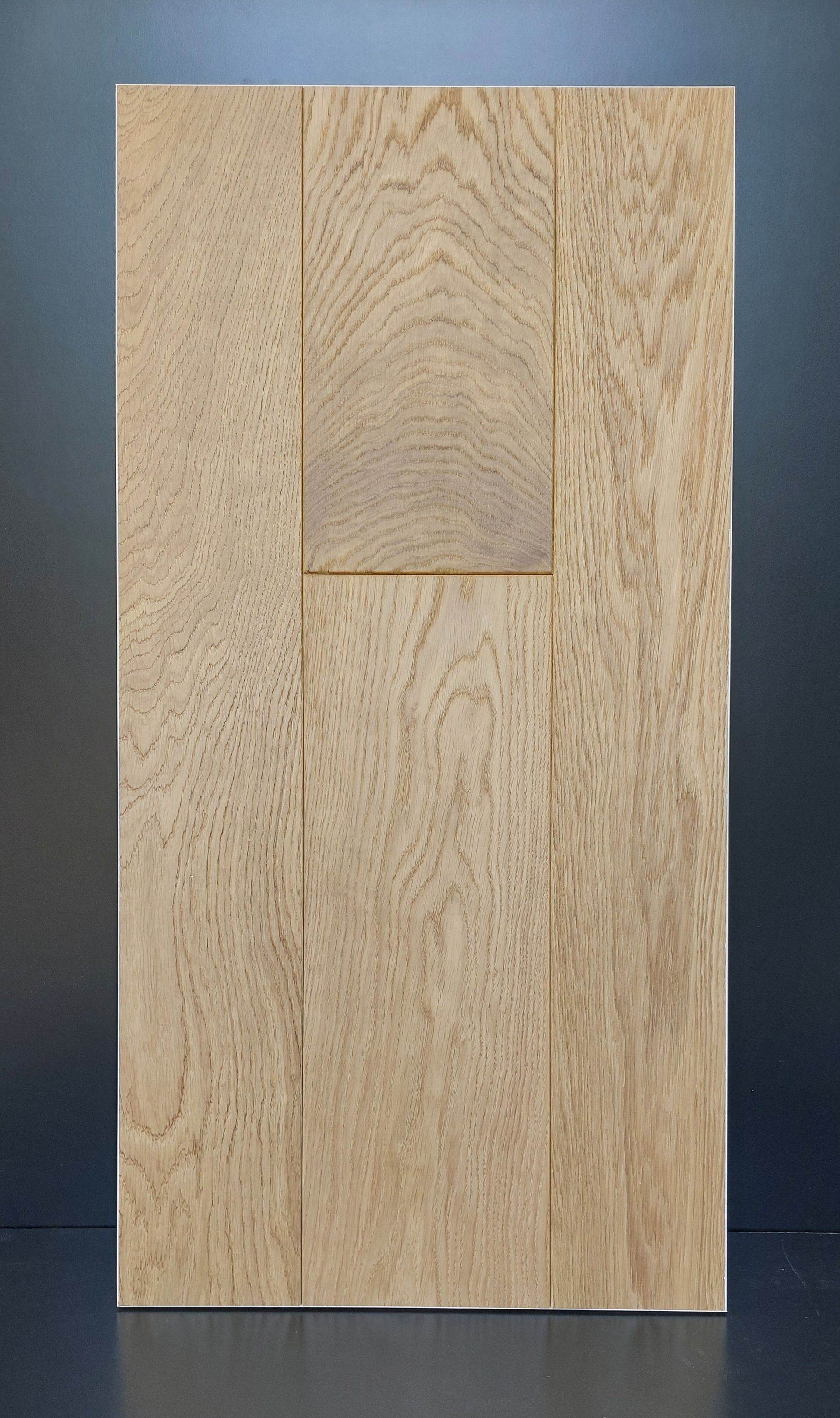 Pannello porta in legno con finitura marrone chiaro. Il pannello è caratterizzato da sezioni rettangolari di diverse dimensioni con venature del legno visibili.