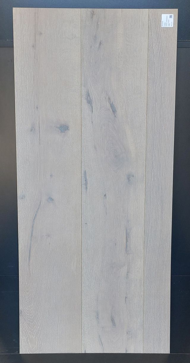 Pavimento in legno grigio chiaro disposto verticalmente. Le venature del legno sono visibili, mostrando la consistenza e le variazioni di colore.