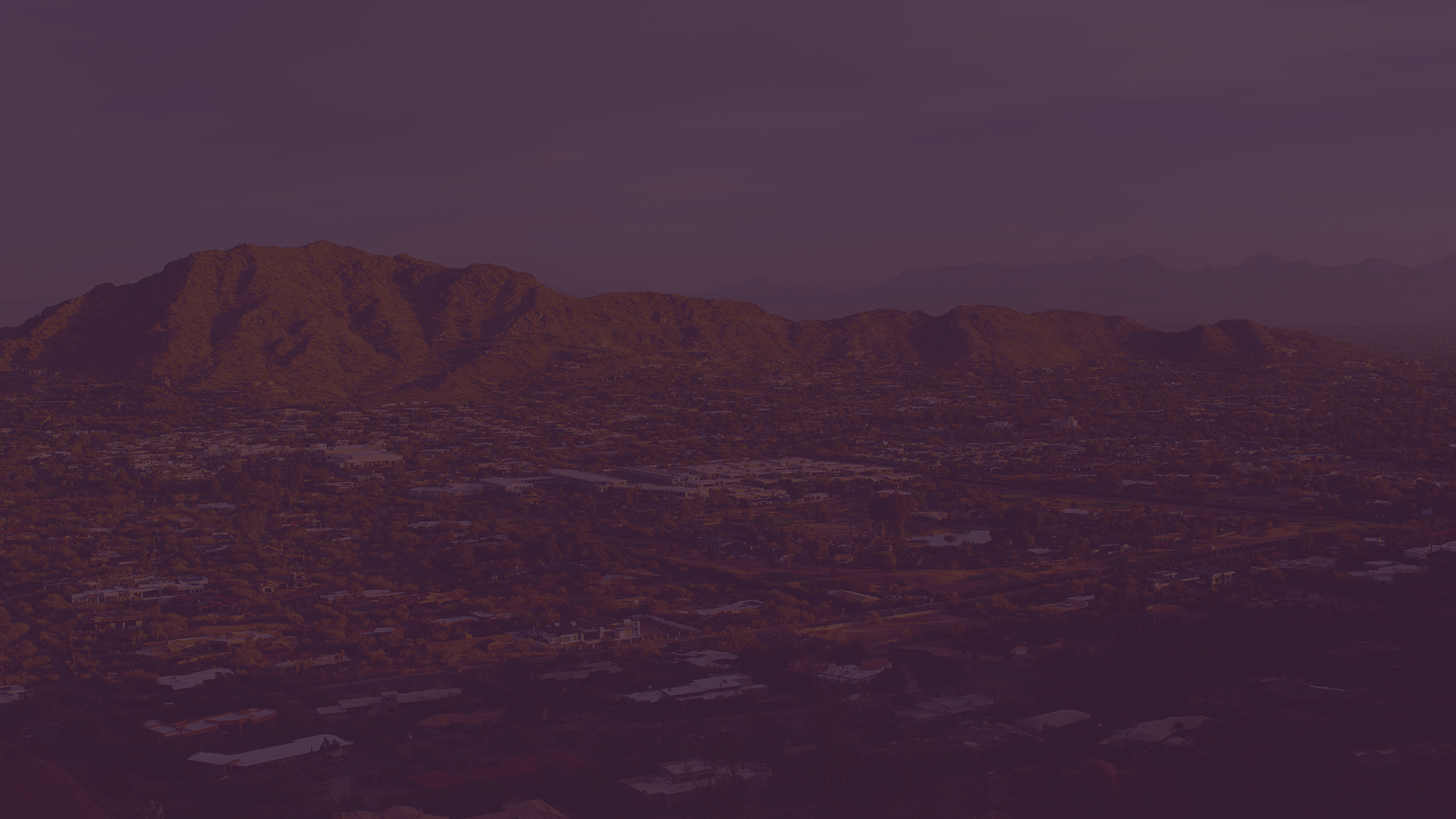 An aerial view of a city with a mountain in the background.