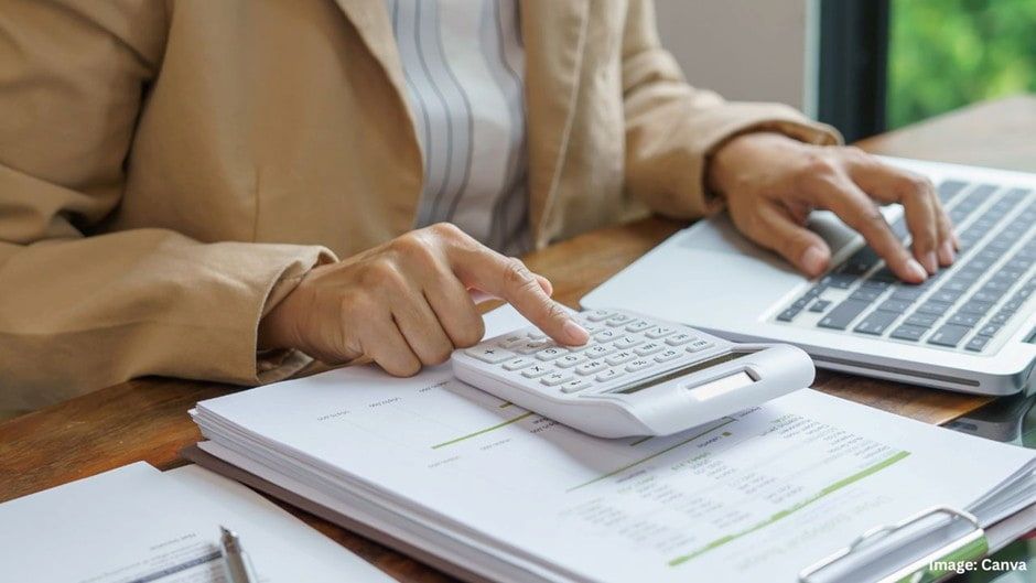 Person Using a Calculator and Laptop, Reviewing Documents at a Desk — Into Finance Lending Solutions in Pacific Palms, NSW