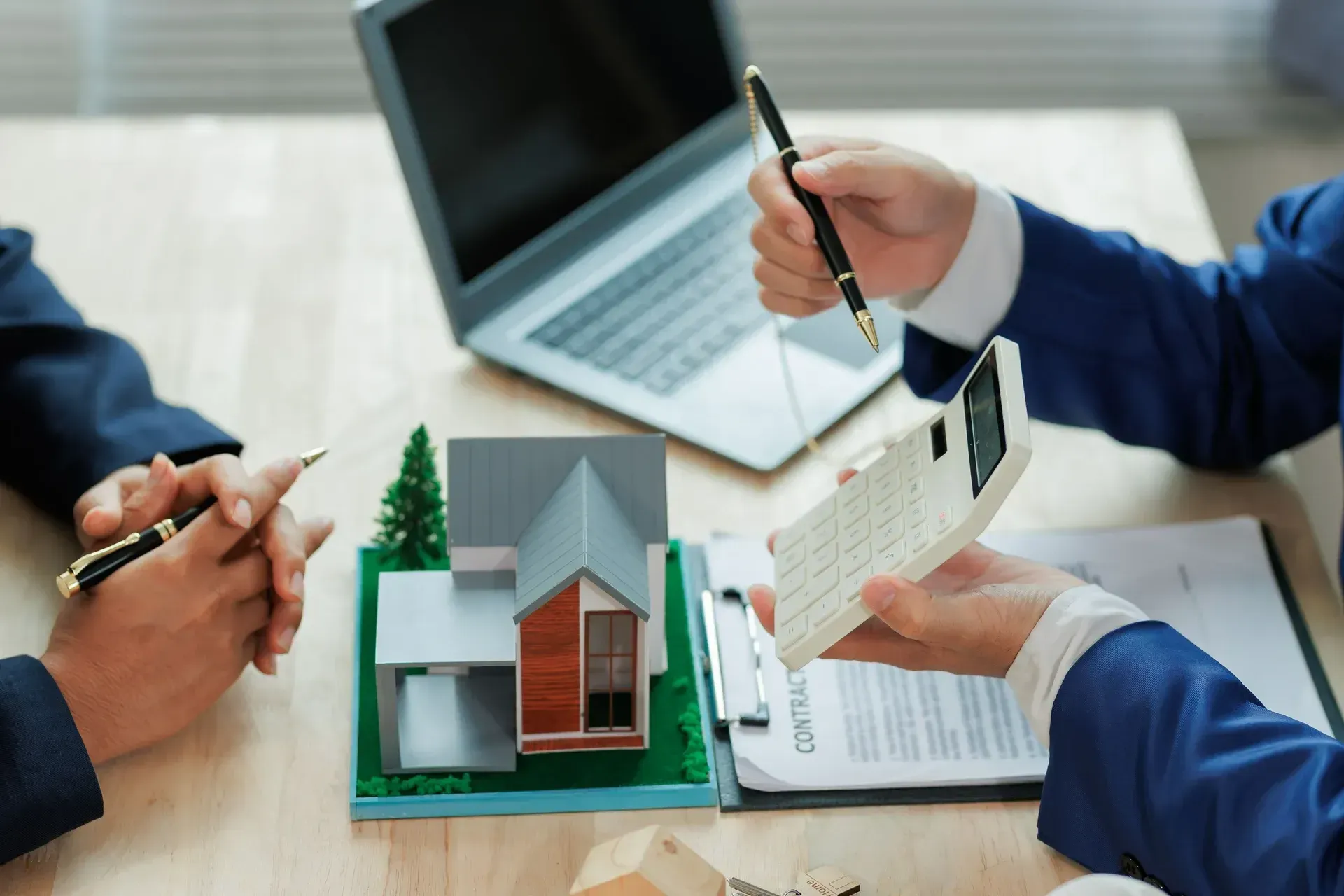 People at Table With House Model — Into Finance Lending Solutions in Coomba Bay, NSW