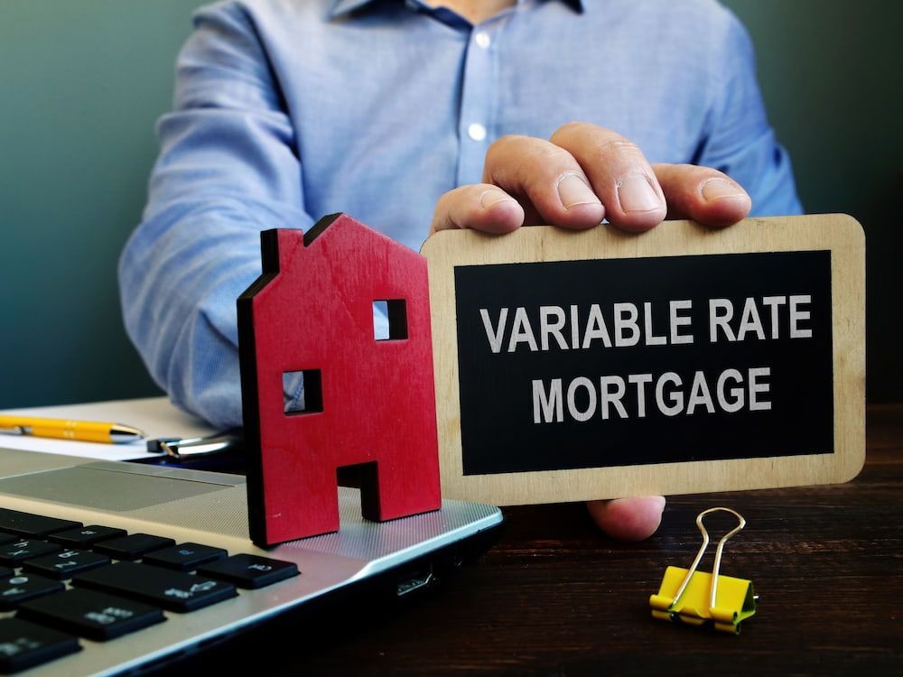 Person Holding a Sign and Red House — Into Finance Lending Solutions in Tuncurry, NSW