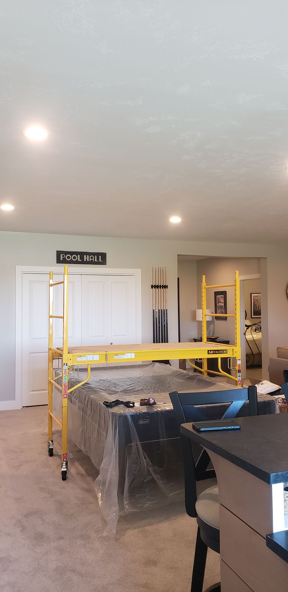 A room with a bed and a scaffolding in it.